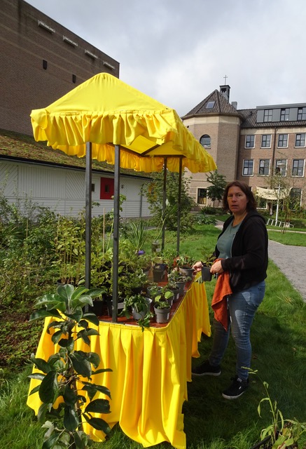 Sonja bij de plantenkraam in de tuin